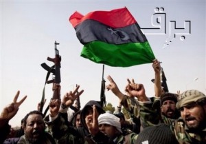Libyan rebels who are part of the forces against Libyan leader Moammar Gadhafi hold a pre-Gadhafi flag as they celebrate after fighting against troops loyal to Gadhafi and capturing  the oil town of Ras Lanuf, eastern Libya, Saturday, March 5, 2011. Rebel fighters have captured the key oil port of Ras Lanouf from the forces of Moammar Gadhafi, in their first military victory in a potentially long, westward march from the east of the country to the capital Tripoli hundreds of miles to the west. (AP Photo/Kevin Frayer)