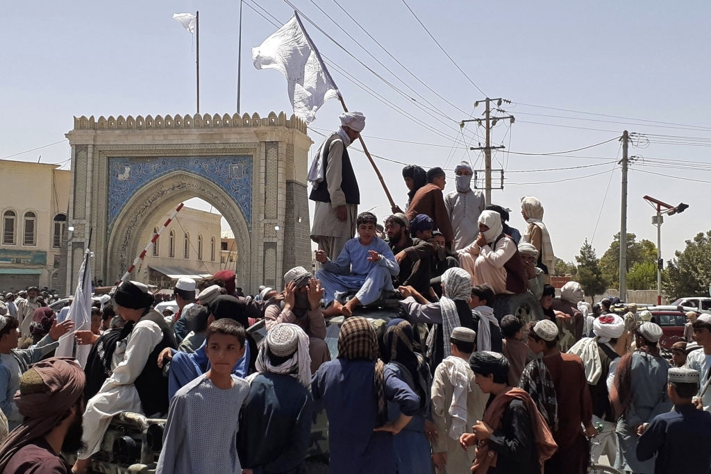 Taliban fighters stand on top of a truck. Taliban victory is a boon to AQ in Afghanistan